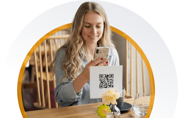 Restaurant guest scanning a QR code on the table to open a digital menu on a smartphone
